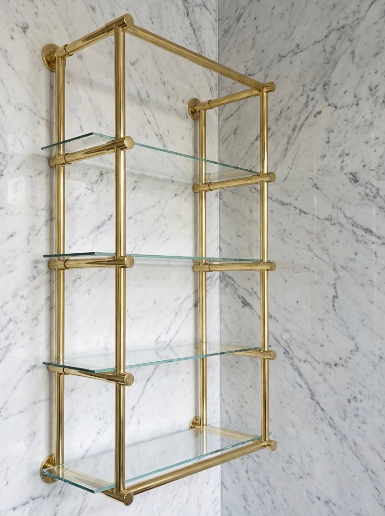 Custom brass wall shelving with glass shelves fabricated in Dallas